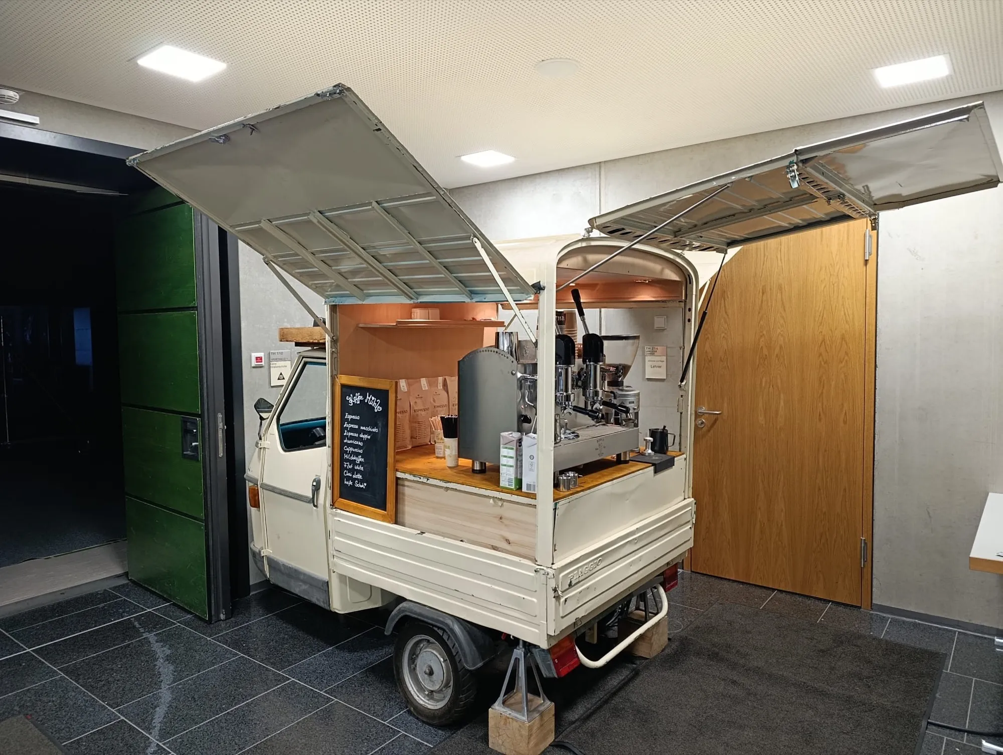 Cremefarbene Kaffee Ape mit hochgeklappten Seitenwänden und Espressomaschine in der Eventhalle Hirschaid