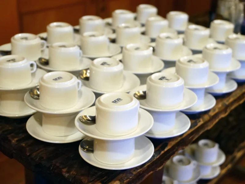 Gestapelte weiße Kaffeetassen auf einem Holztisch